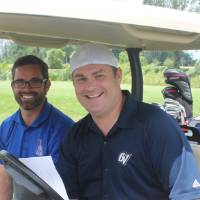 2 men in golf cart ready to play